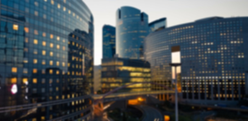 Glass office towers lit at dusk in a financial district